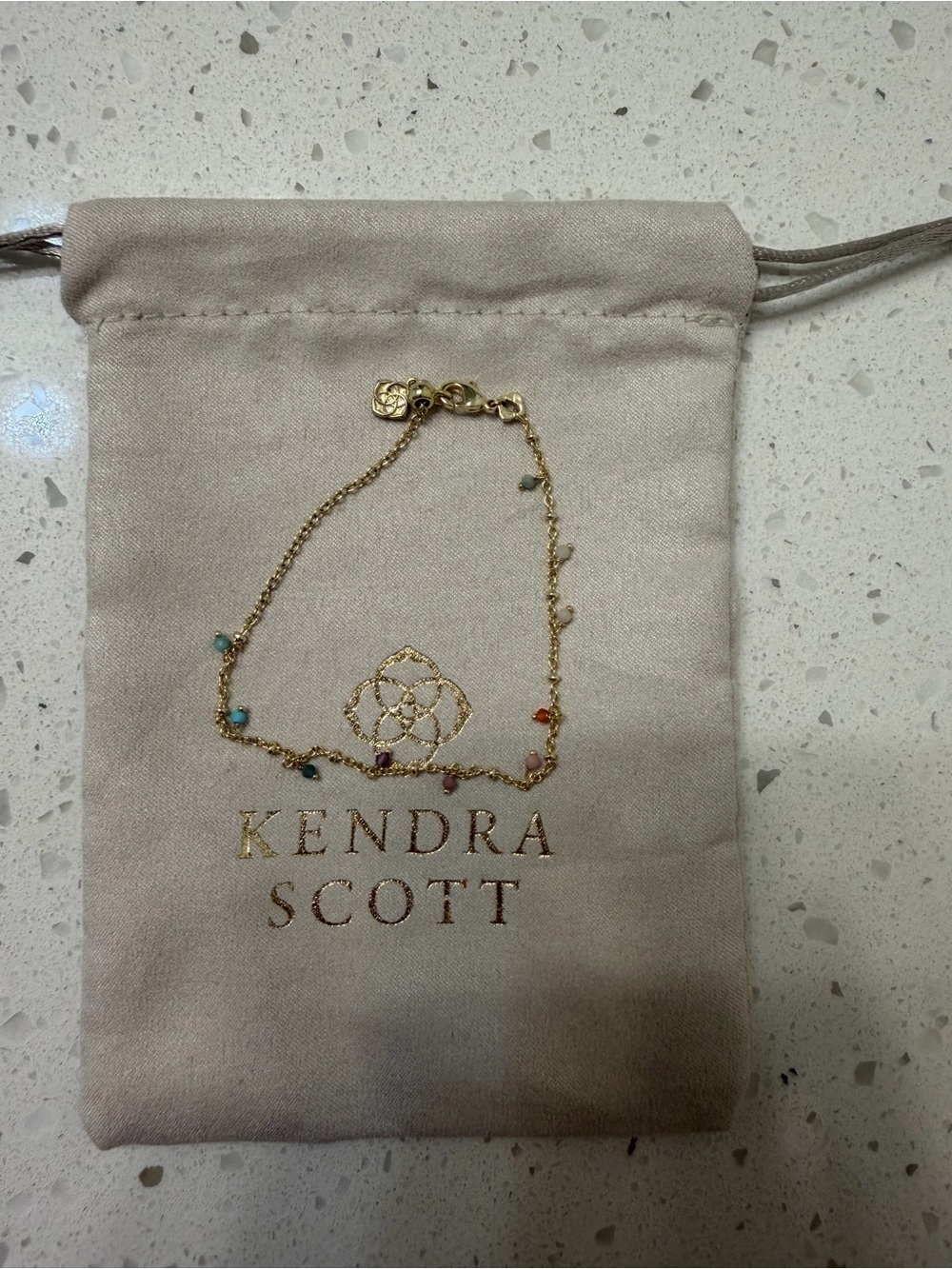Kendra Scott jewelry pouch with delicate chain bracelet